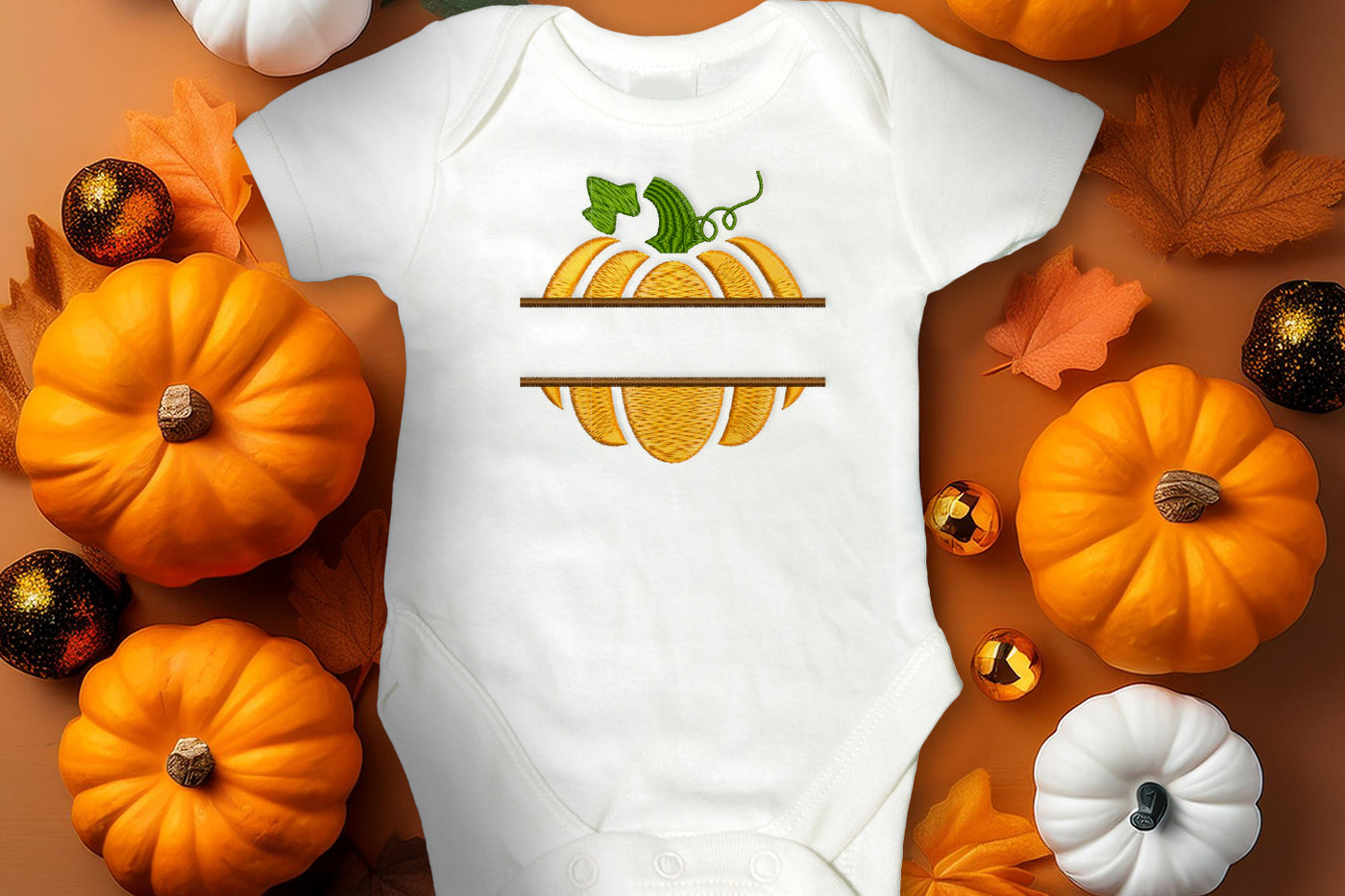 White baby onesie with pumpkin design surrounded by pumpkins and leaves on a brown background
