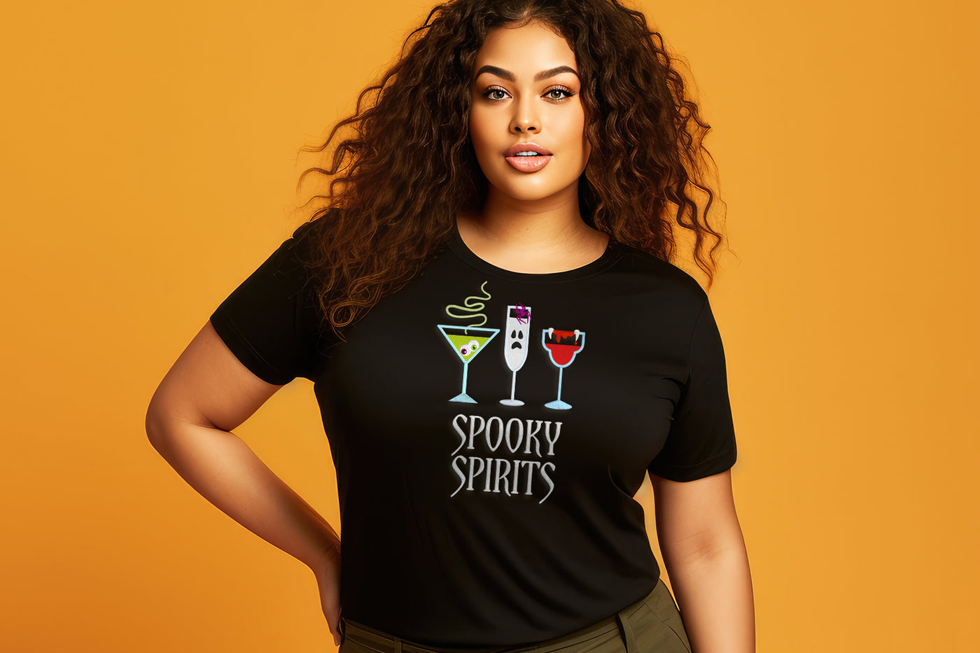 Woman wearing a black t-shirt with 'Spooky Spirits' embroidery design on an orange background. The design includes Halloween-themed drinks.