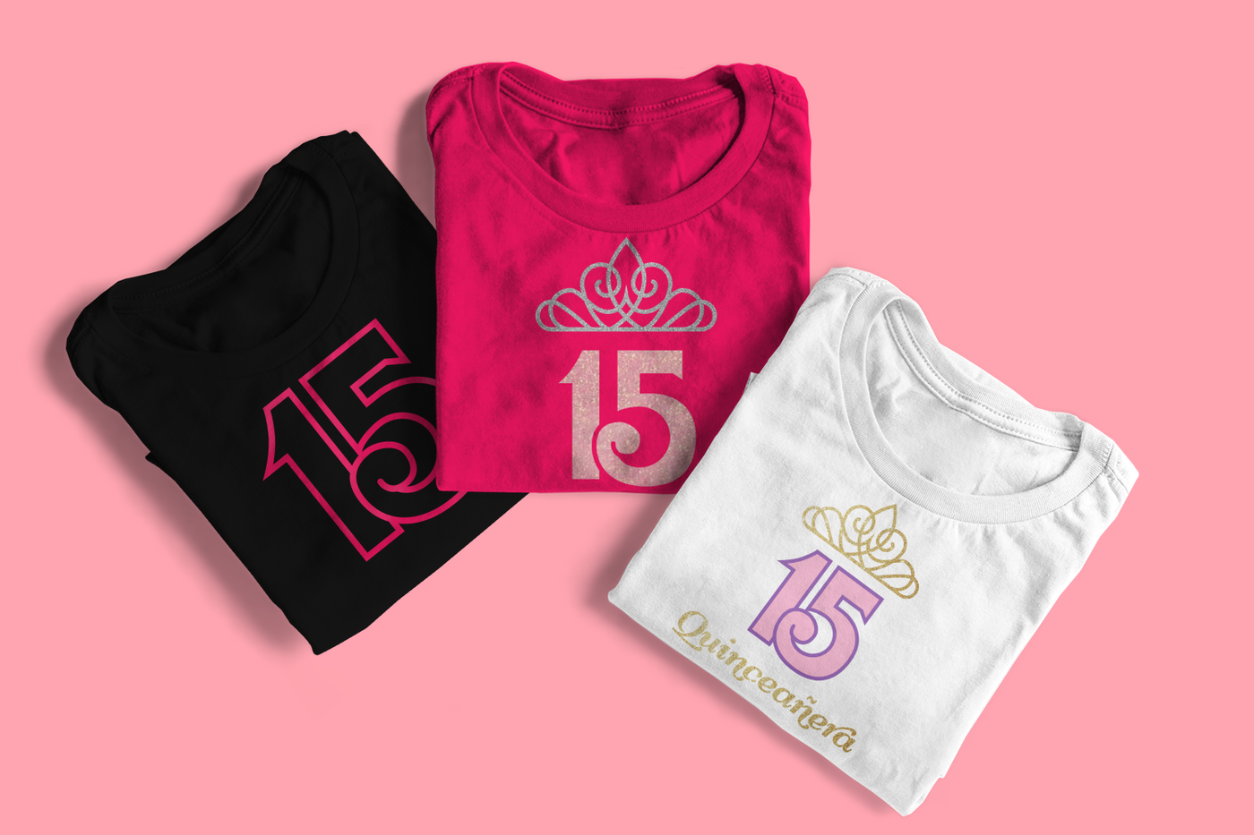Three folded tees on a pink background. Left tee has a large number 15, middle tee has a large 15 with a tiara, and right tee has a 15 with a tiara and the word "Quinceañera" below.