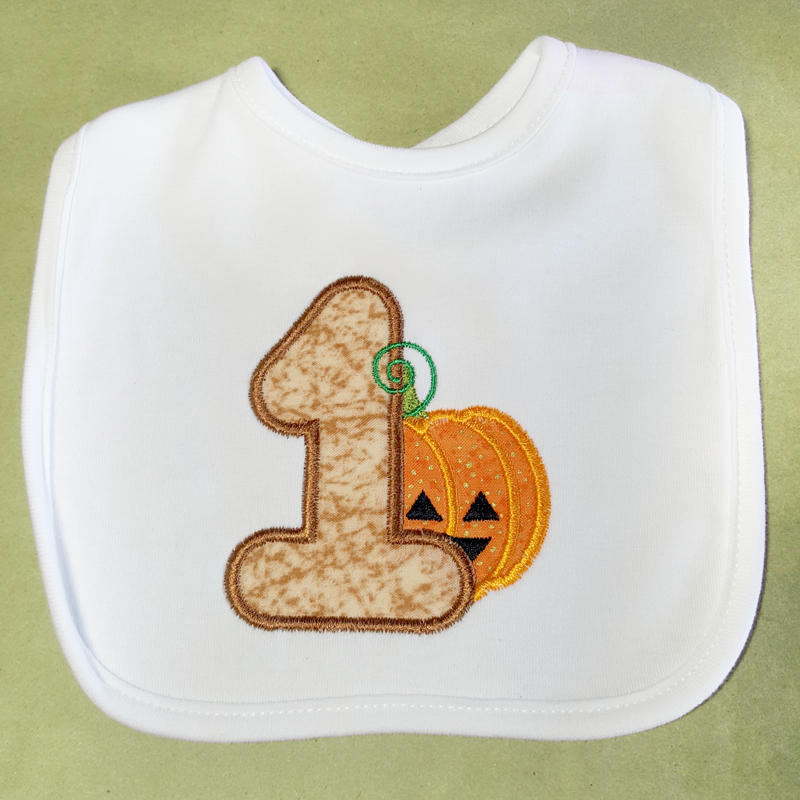 Bib with a large applique 1 and a cute Jack-o-lantern.