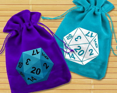A purple and turquoise dice bag sit on a bamboo placemat background. The purple bag has a turquoise D20 with black numbers. The turquoise dice bag has a white single color D20 with the numbers as knockouts.