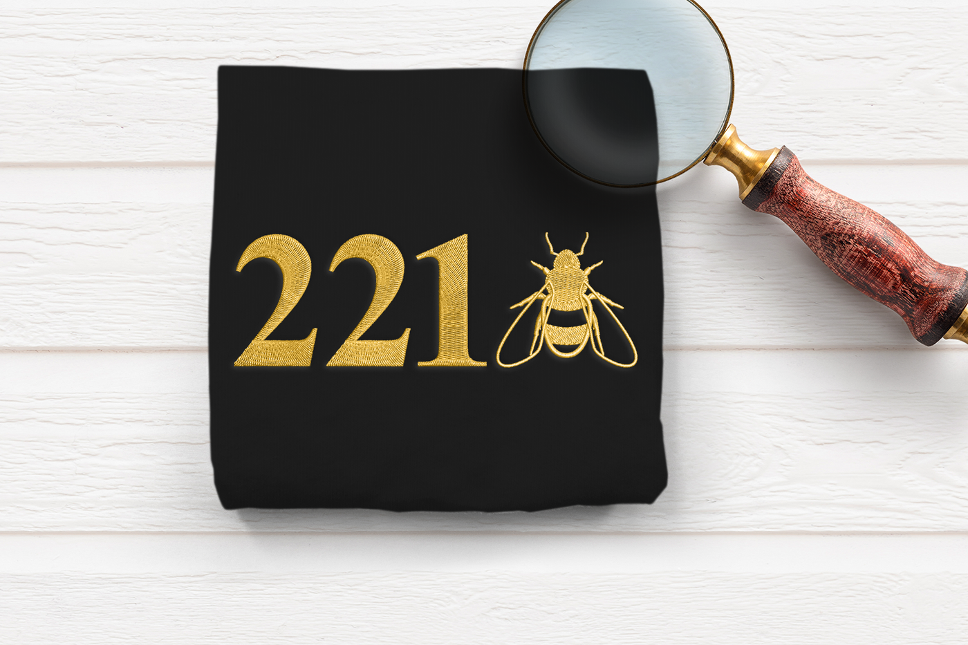 Embroidery of the number 221 with a realistic bee embroidery next to it.