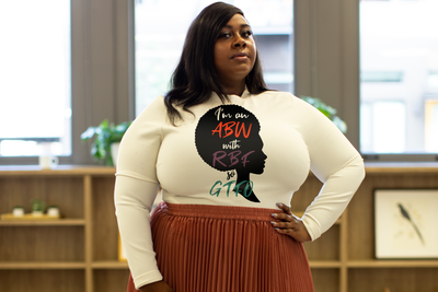 Black woman wearing a shirt with the design of a silhouetted black woman with natural hair in an afro style and the words "I'm an ABW with RBF so GTFO." 