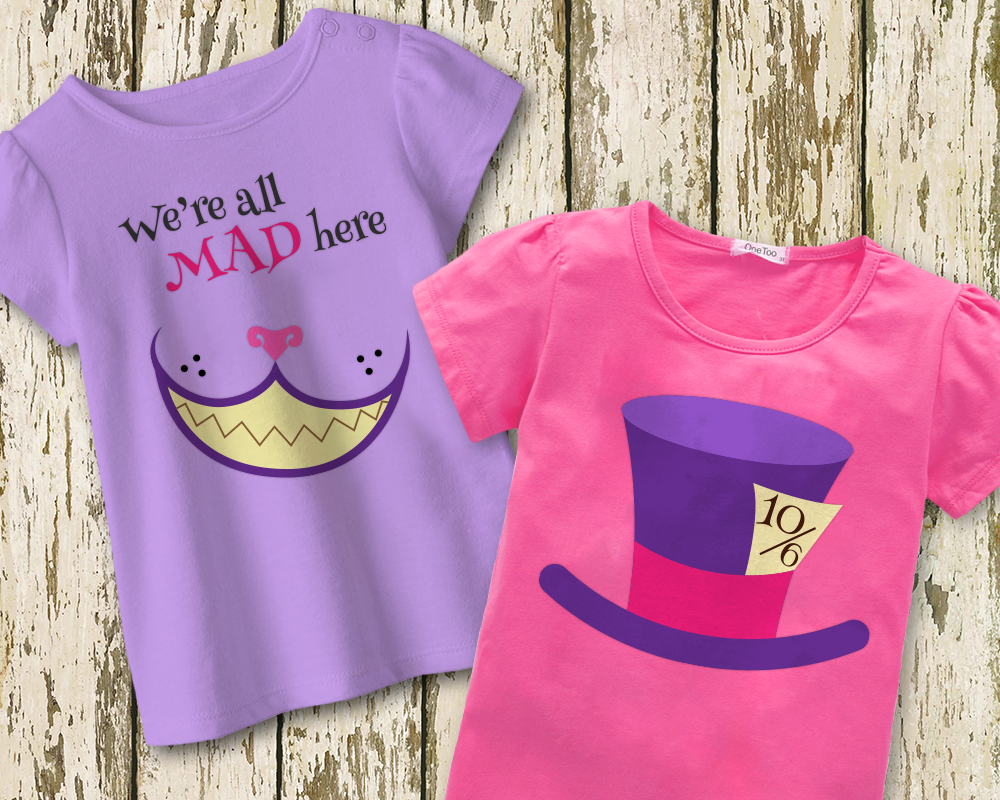 Two children's shirts on a weathered wood background. The left shirt is lavender with a Cheshire cat grin and says "we're all mad here." the right shirt is bright pink with a purple top hat with a card that says "10/6."
