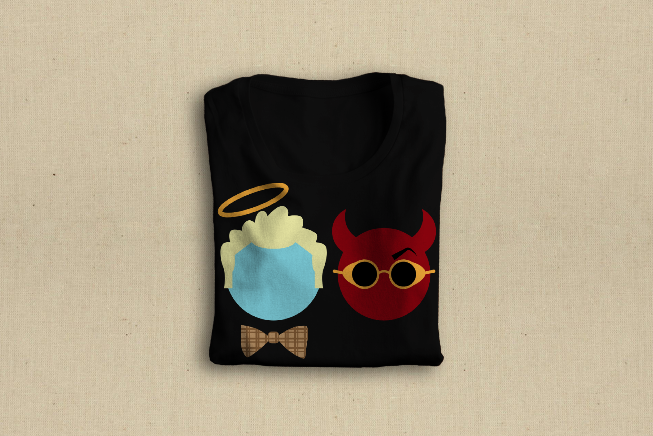 A folded black tee on a beige background. The design on the left of the shirt has a blue circle with blonde hair, a halo, and a plaid bow tie. The design on the right is a circle with devil horns, steampunk sunglasses, and a single raised eyebrow.