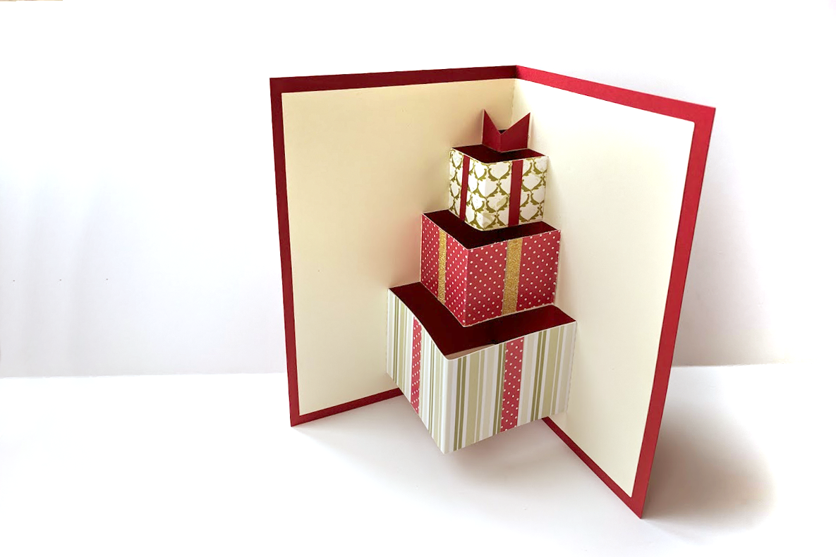 Inside of a greeting card with pop up gift boxes in Christmas wrap.
