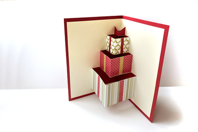 Inside of a greeting card with pop up gift boxes in Christmas wrap.