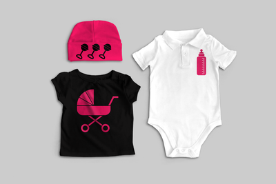 A baby shirt, knit cap, and polo onesie sit on a grey background. The hat is hot pink with 3 black rattles on the brim. The shirt is black with a hot pink baby stroller. The polo is white with a hot pink baby bottle.