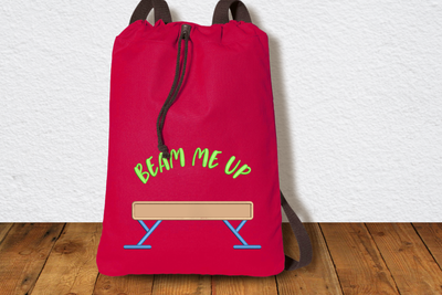 Drawstring bag with a balance beam applique and embroidered words "beam me up"