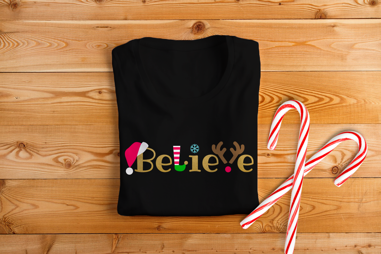 Black tee that says "Believe" with Christmas icons incorporated into the words.