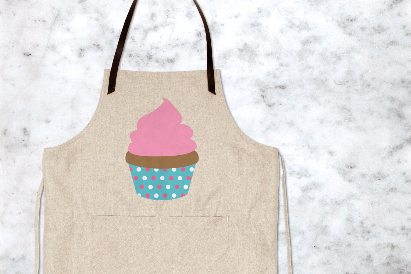 Frosted cupcake design with polka dot wrapper on an apron
