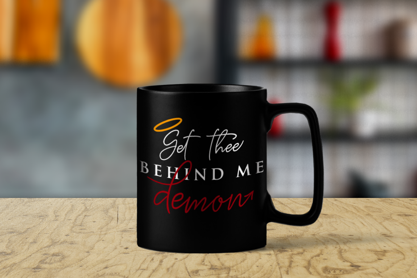 A mug with the quote "Get thee behind me demon." The G has a halo and the word demon has a devil tail at the end.
