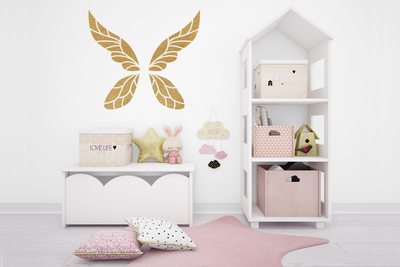 Detailed fairy wings in gold on the wall of a child's play room.
