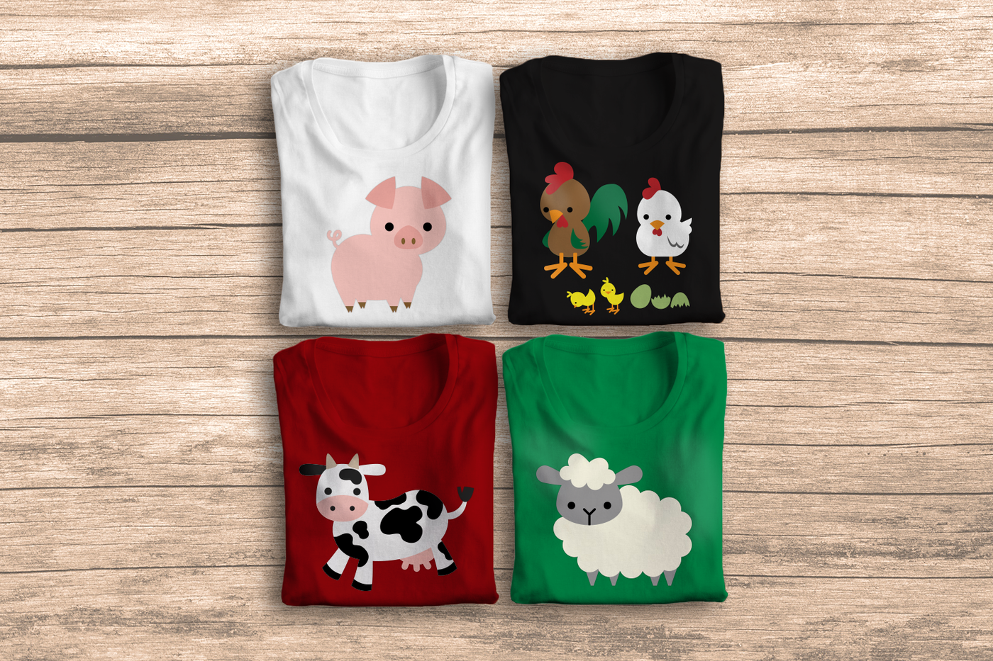 Four folded tees, each with different cute cartoon animals. There is a pig, a cow, a sheep, and a family of chickens.
