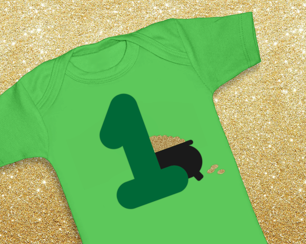 Green onesie with a large 1. The number has a pot of gold behind it.