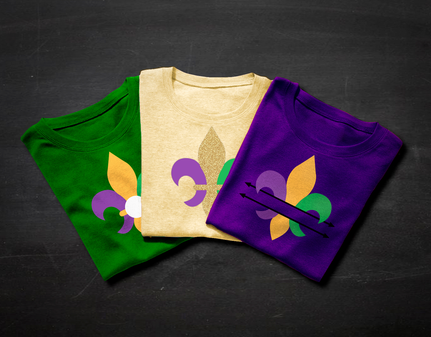 Three folded tees, each with a fleur de lis design. One has a split in the middle, and one has a center circle for adding a monogram.