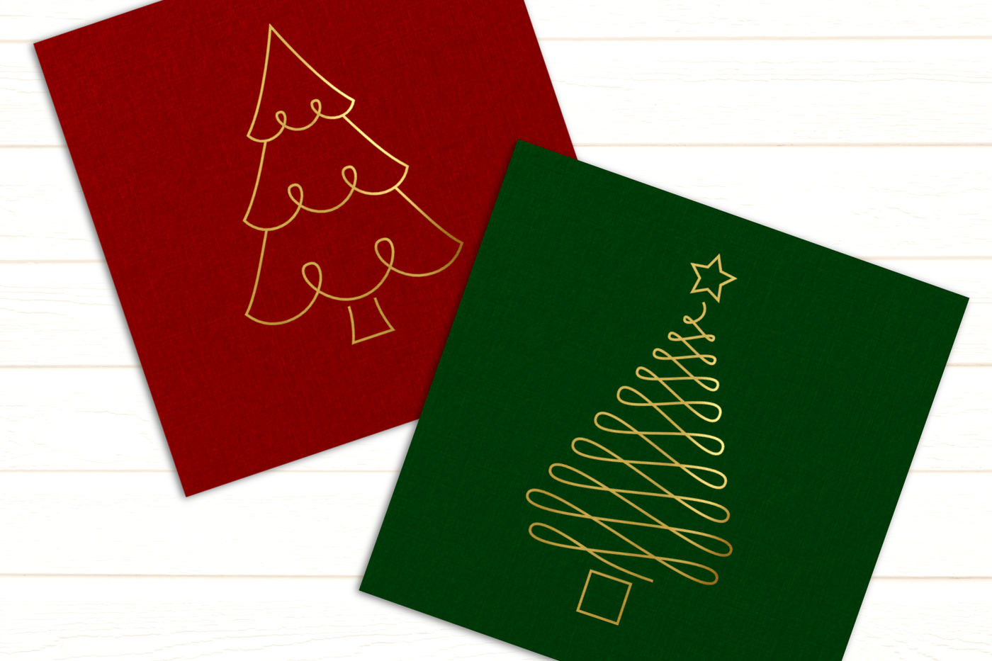 A red and green card on a white background. Each has a gold stylized line drawing of a Christmas tree.