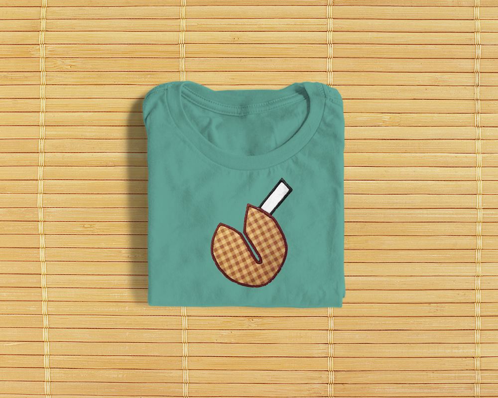 Folded shirt with an applique fortune cookie.