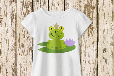 A white tee with a frog on a lily pad wearing a crown.
