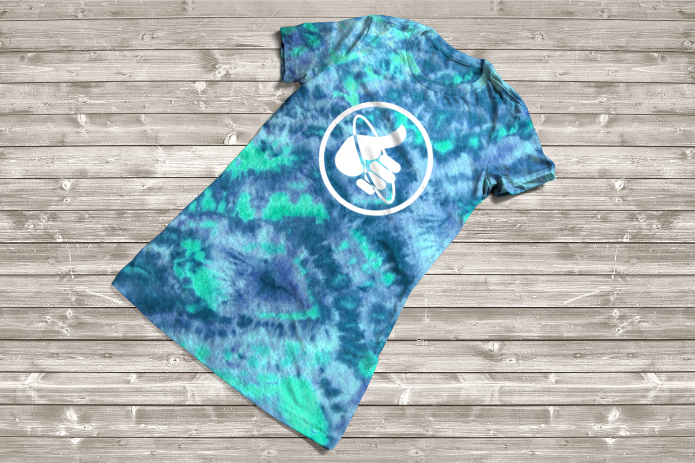 Tye-dyed tee with a thumb giving the hitchhiking gesture with a ring around it inside of a circle.