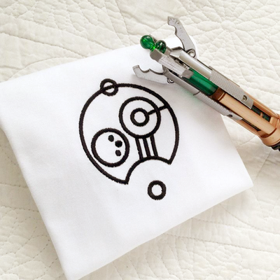 custom gallifreyan embroidery in black on a white piece of fabric