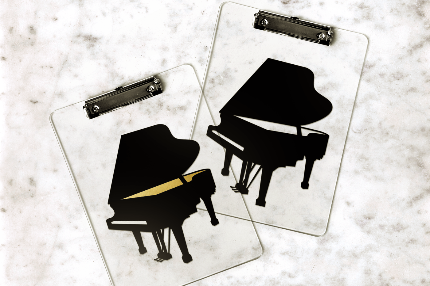 Two clipboards with a grand piano design on them.