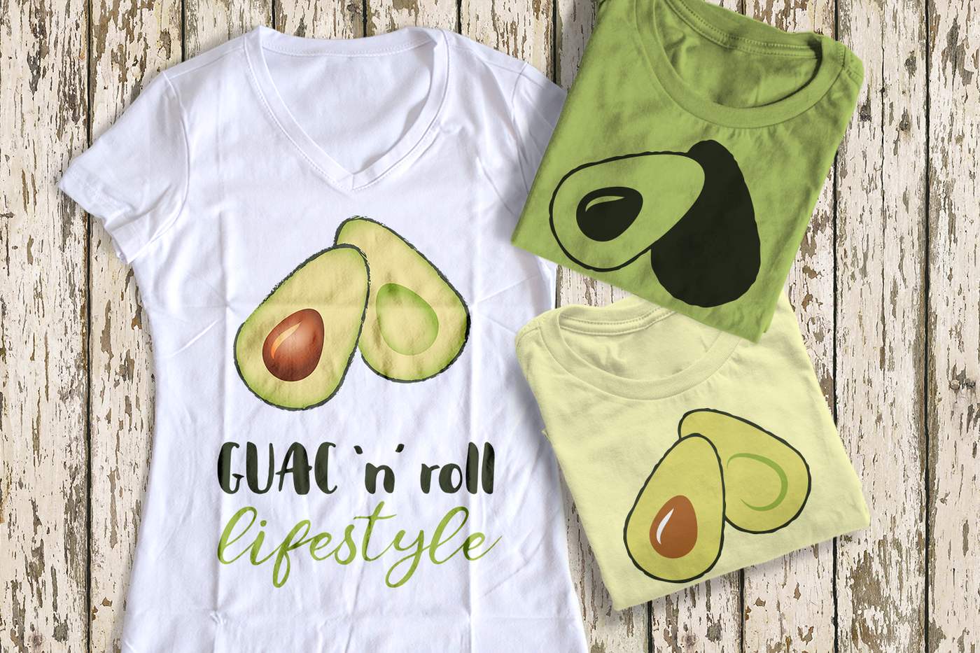 Three folded tees. Each has an image of an avocado sliced in half. One says "Guac 'n' roll lifestyle"