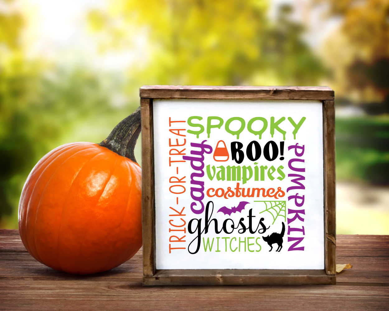 Square Halloween poster. The design is subway word art and features words related to Halloween. Also includes a bat, a cat, a candy corn, and a spiderweb nestled within the words.