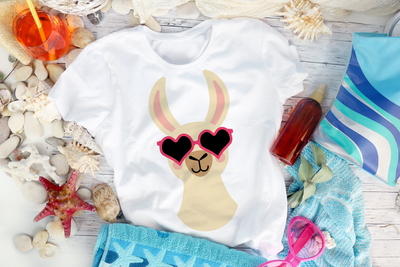 Tee with a llama wearing heart sunglasses shown from the neck up