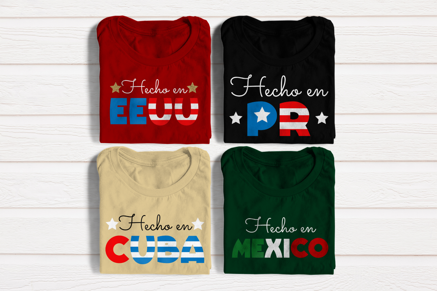 Four folded tees. They say "hecho en EEUU," "hecho en PR," "hecho en Cuba," and "hecho en Mexico." The country names are stylized to resemble the country's flag.