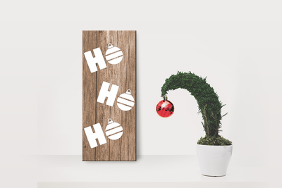 Vertical sign with the words "ho ho ho." Ornaments are in place of the Os.