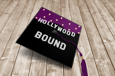 Grad cap with "Hollywood Bound" and silhouette of hills. Fairy lights look like stars in the sky.