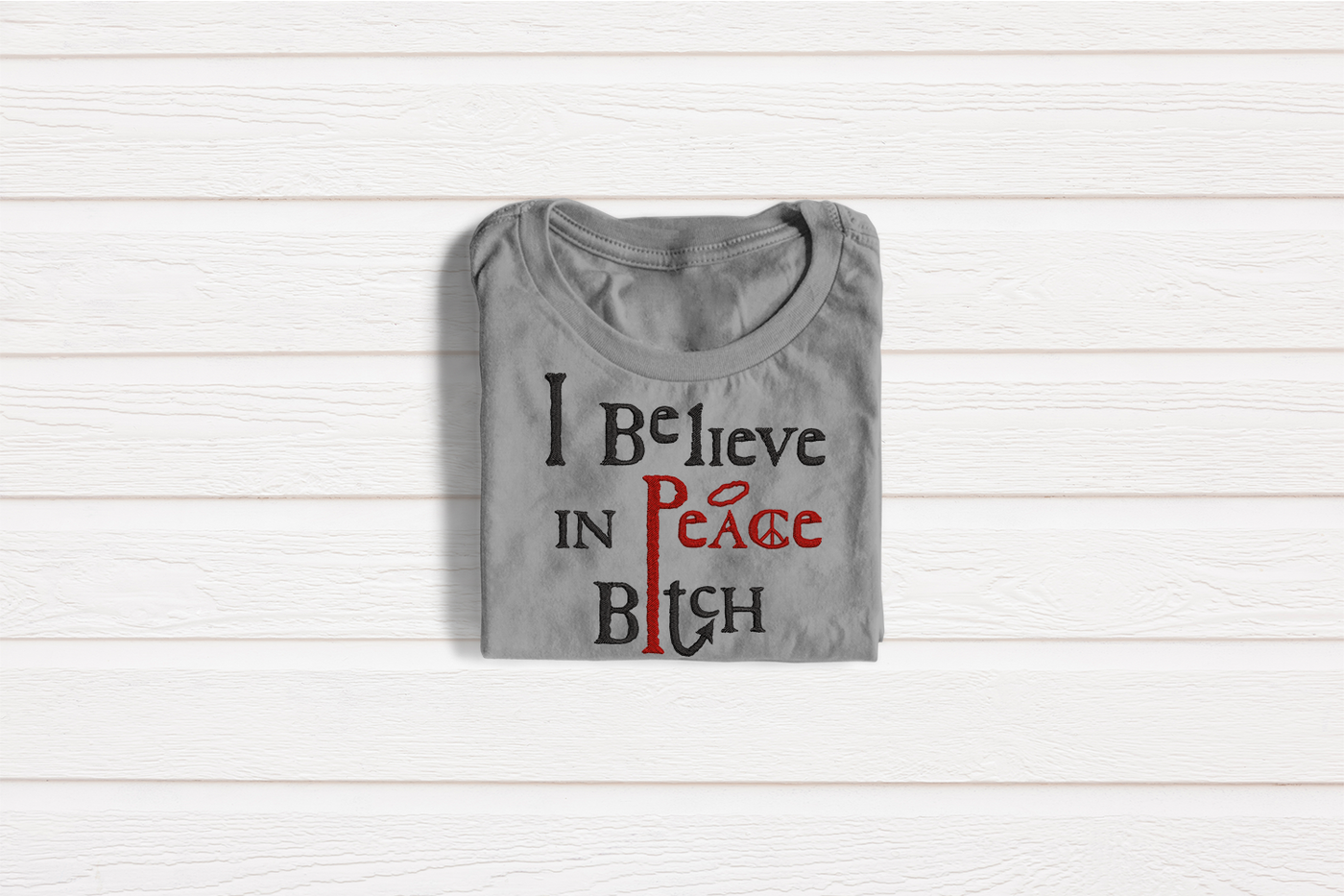 Folded shirt with the embroidered phrase "I believe in Peace Bitch."