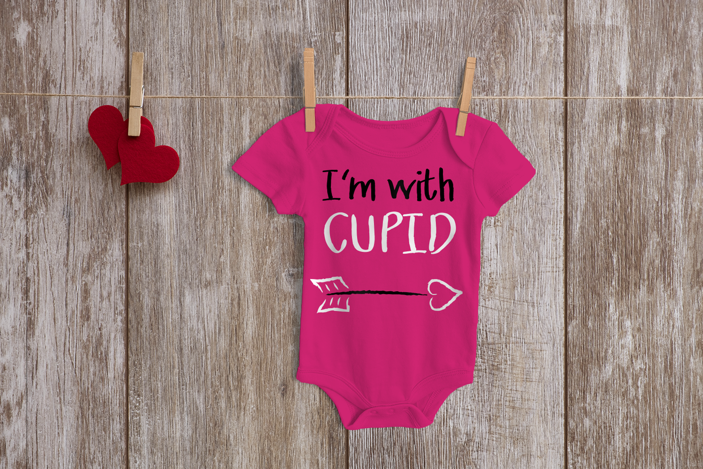 Baby onesie with a design that says "I'm with cupid" and a cupid's arrow.