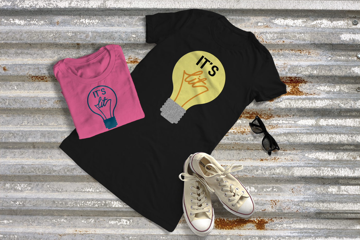 Two tees with a light bulb design. Light bulb says "It's lit" inside.