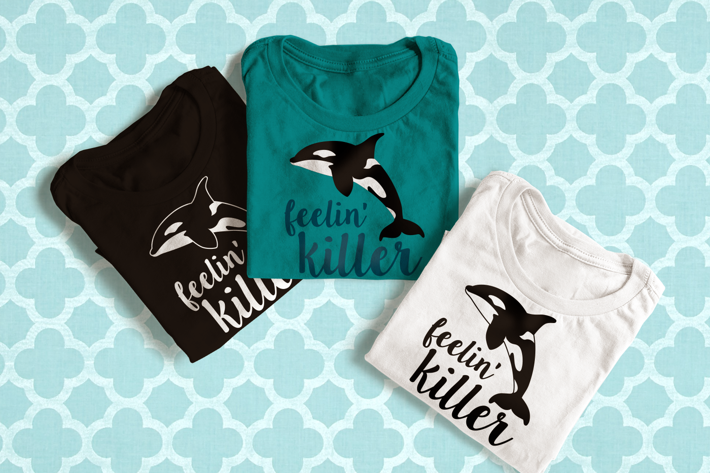Three folded tees. Each has the image of a killer whale and text that says "feelin' killer."