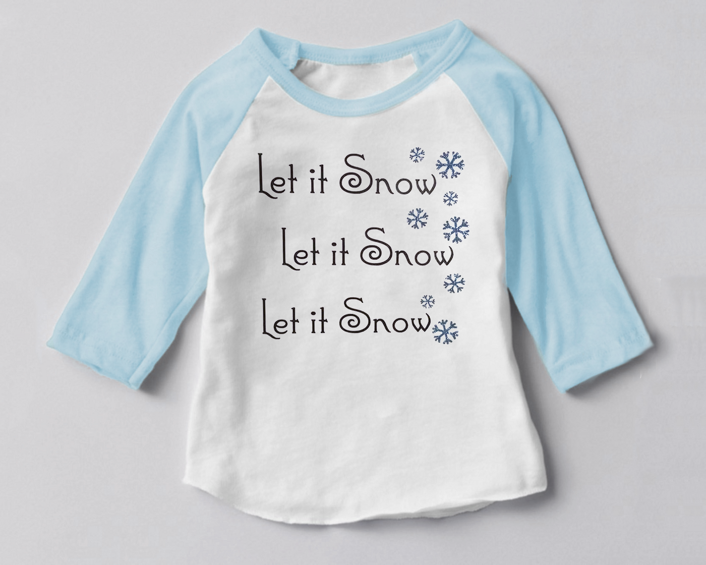 Raglan tee with a design that says "Let it Snow" three times and snowflakes along the side.