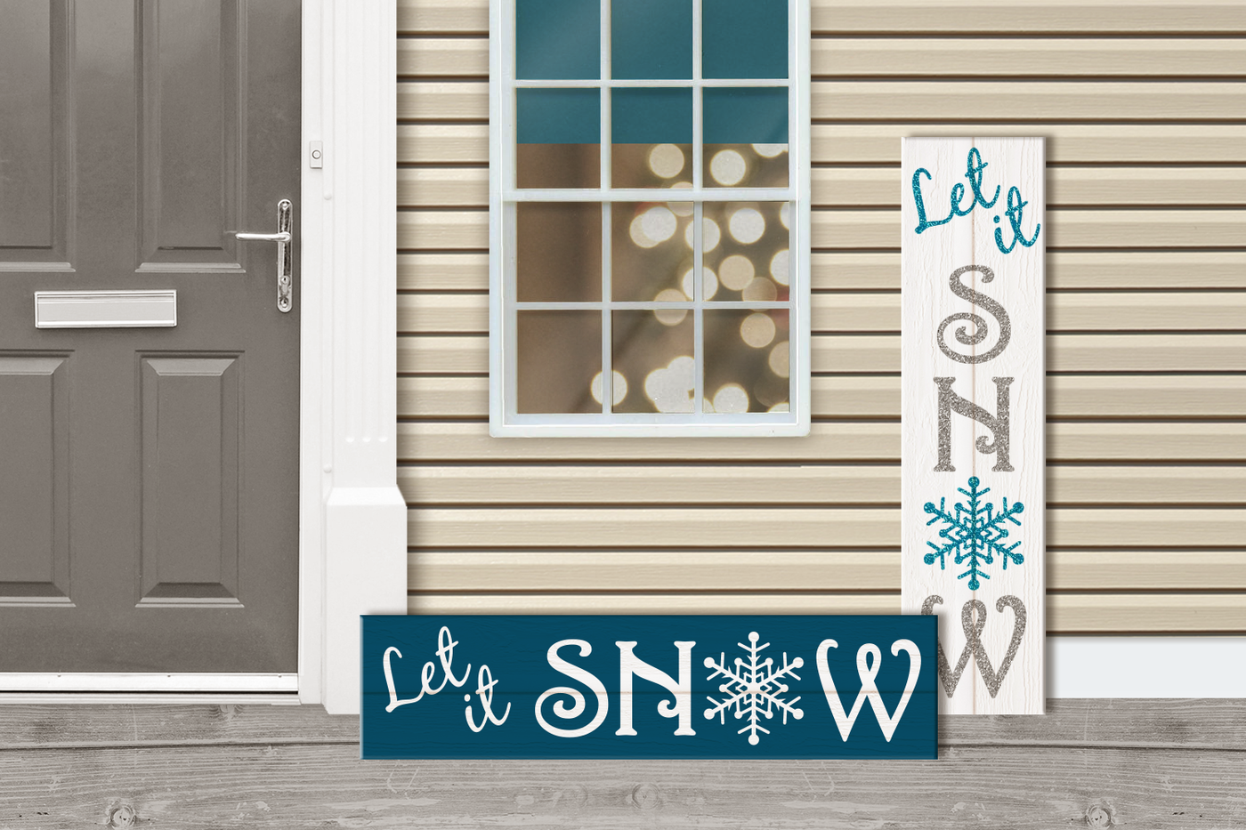 Vertical and horizontal signs at a front door. An out of focus Christmas tree is visible through the window. Each sign says "Let it SNOW" with a snowflake for the O.