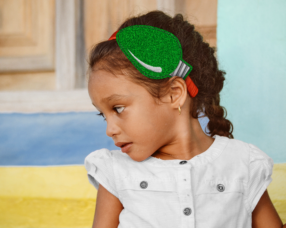 A young Latinx girl wears a headband slider featuring a Christmas light