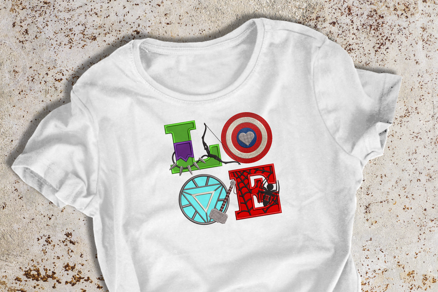 Shirt with an applique design that says "LOVE" set on a square. The LOVE is spelled out with various comic symbols.