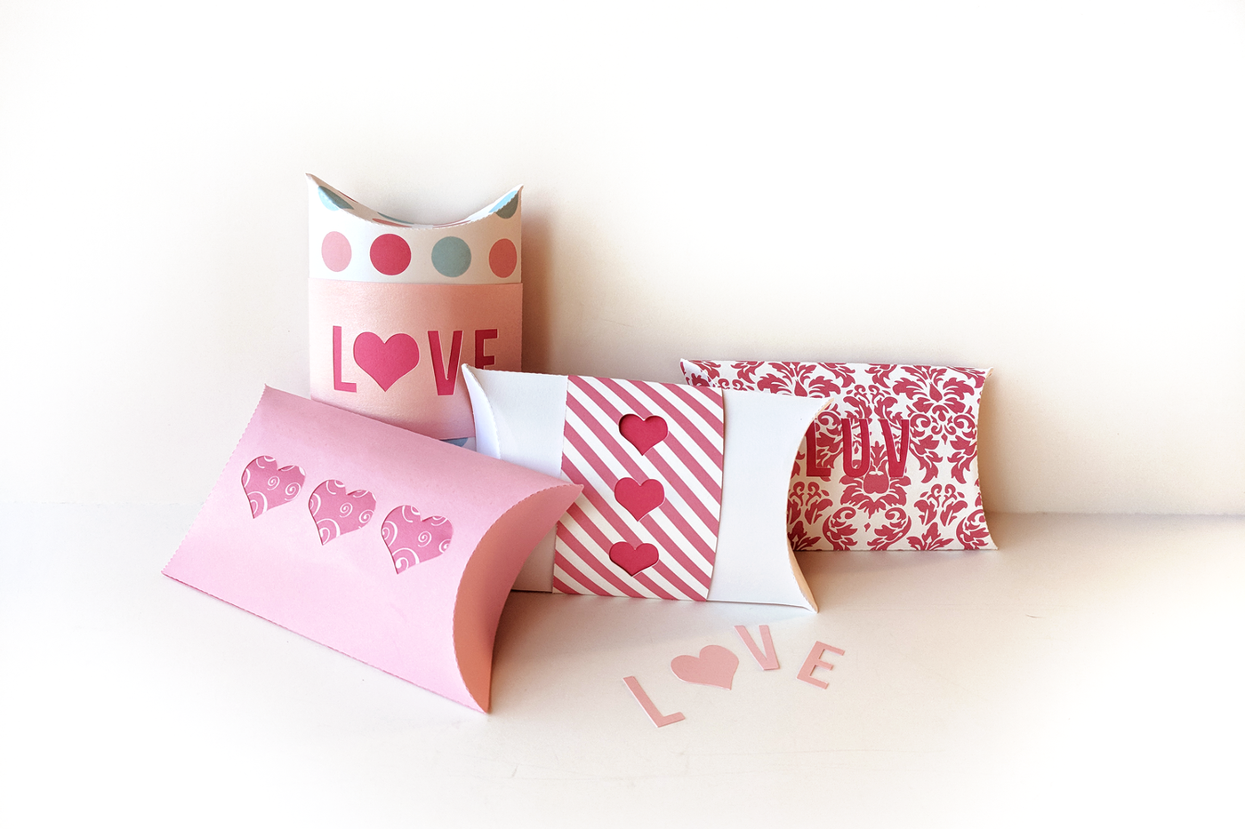 Set of 4 pillow boxes with a love theme. Some have hearts knocked out, others say "LOVE" or "LUV."