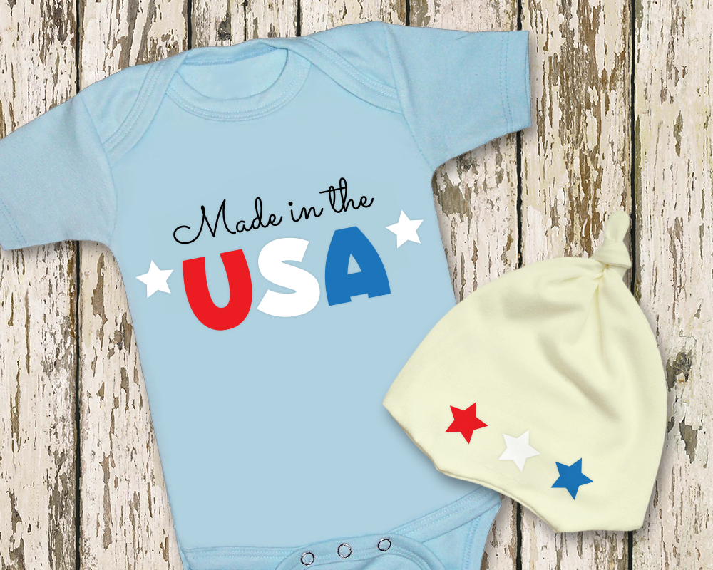 Baby onesie with "Made in the USA" design. Next to it is a knotted cap with 3 stars.