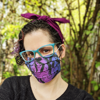 White presenting Latinx woman wearing a pleated fabric face mask