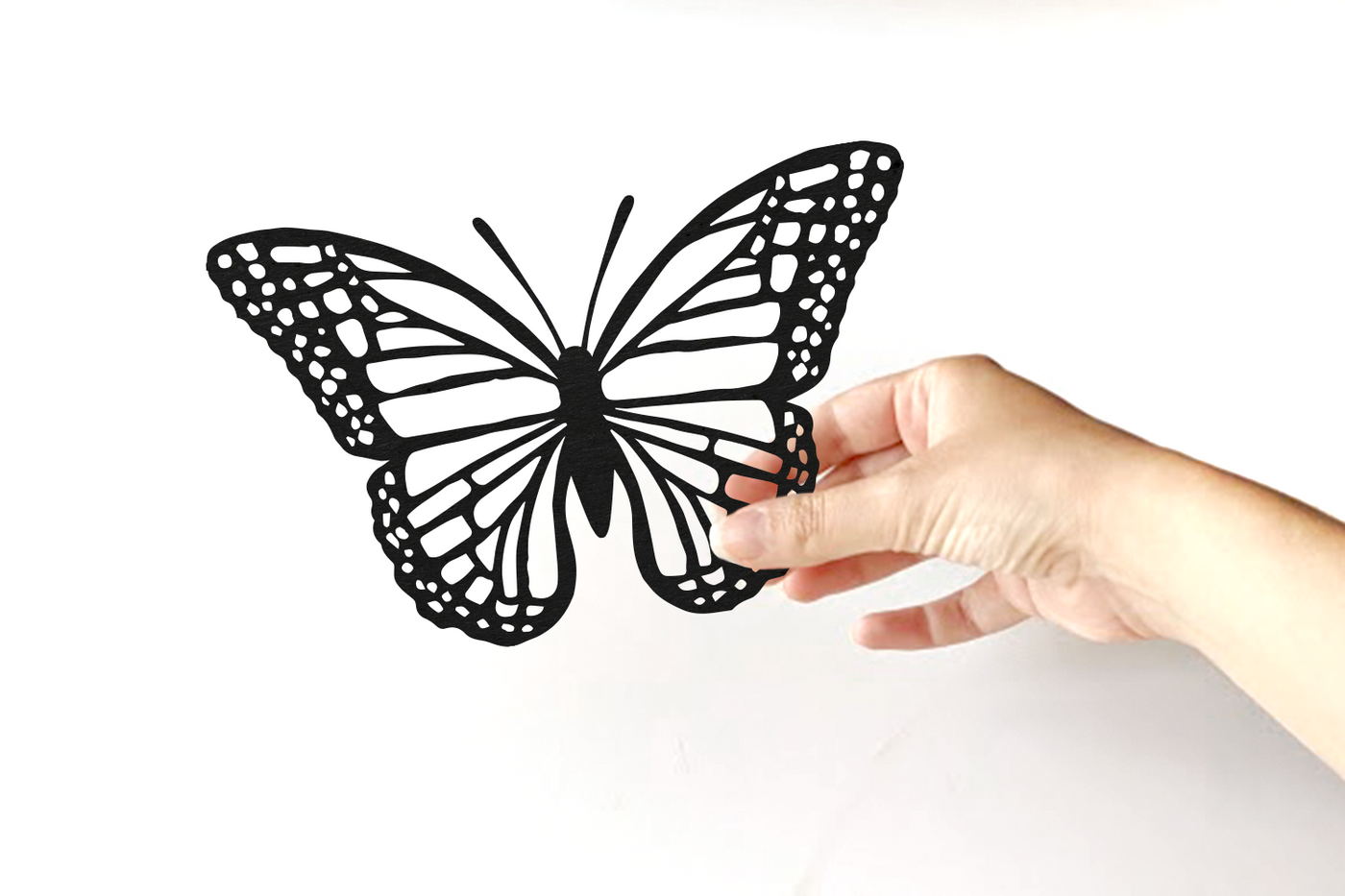 Hand holding a monarch butterfly papercut