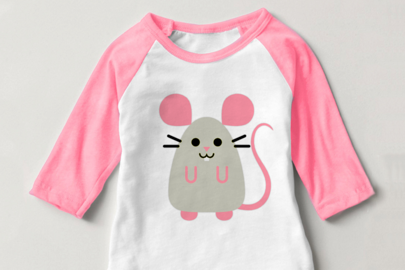 A pink and white raglan child's shirt with a cute mouse design.
