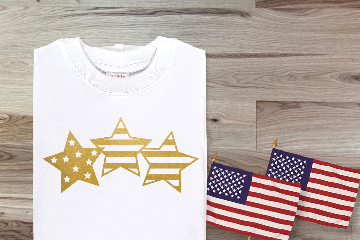 Trio of stars with stars and stripes pattern SVG design. Shown in gold on a white shirt.