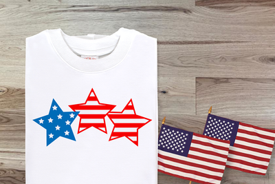 Trio of stars with stars and stripes pattern SVG design. Shown in red white and blue on a white shirt.