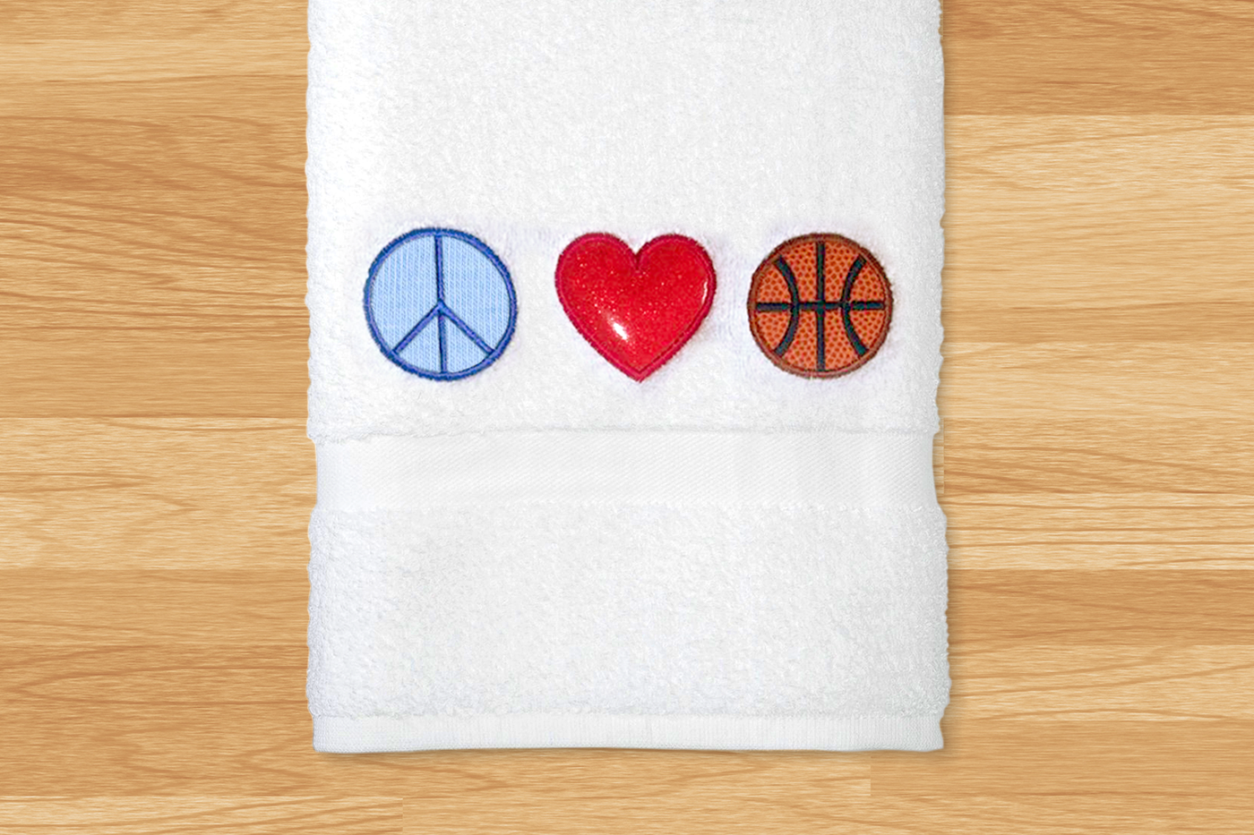 Applique design that has the symbol for peace, a heart, and a basketball.