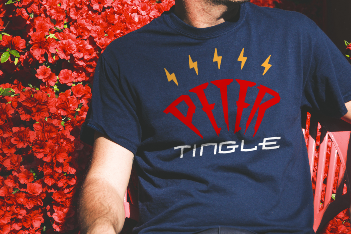 Design that says "Peter tingle" with spark lines above. Shown on a tee shirt worn by a white man.