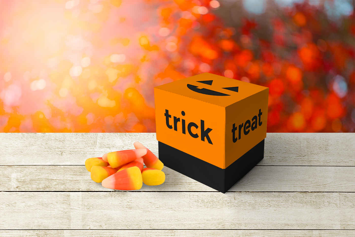 Cube shaped box with a jack-o-lantern pumpkin face cutout at the top, and the words "trick" and "treat" along the sides.